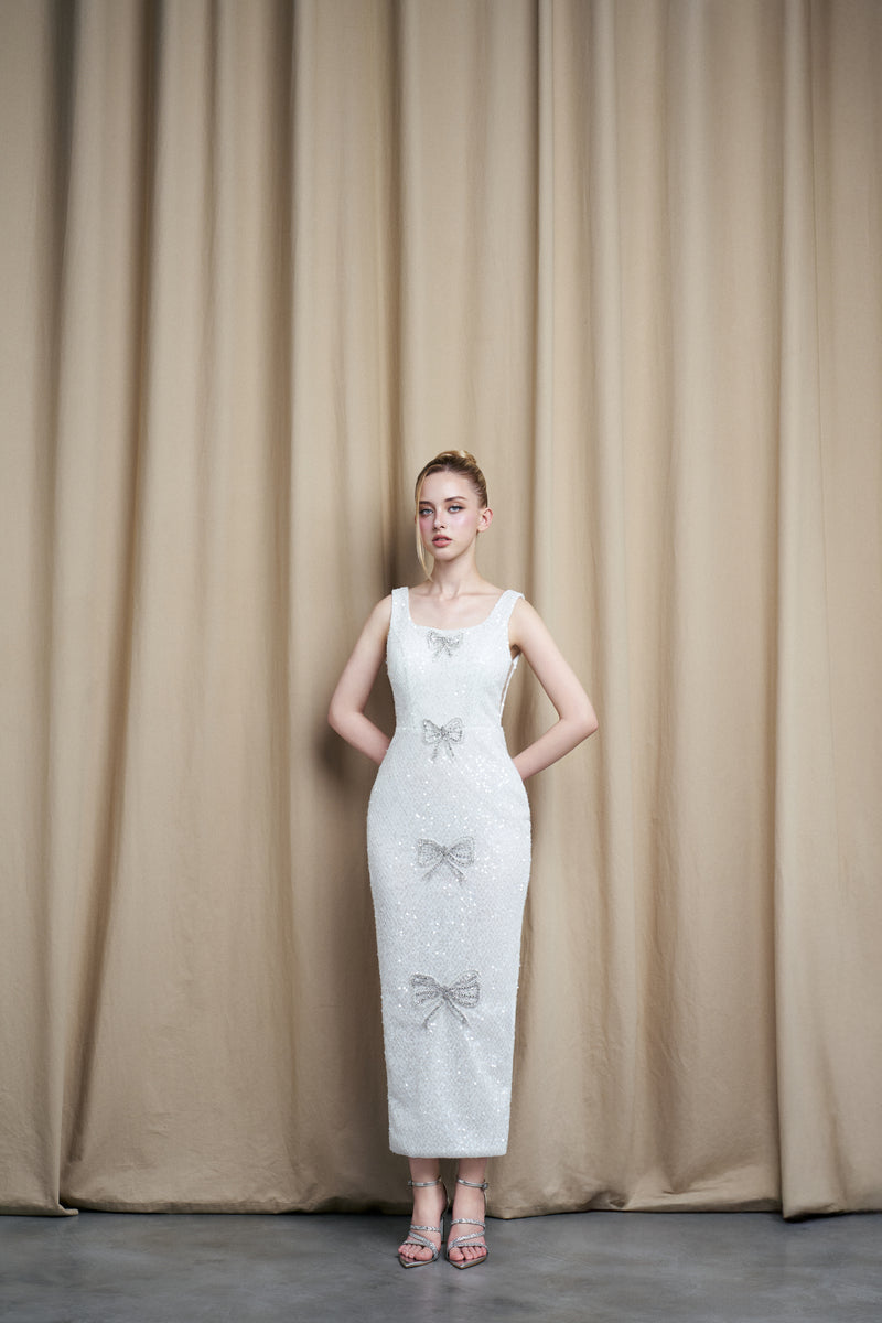 Ivory sequined scoop neck gown with bow accents by HACCHIC COUTURE, featuring elegant design and shimmering details.