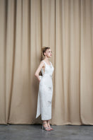 Ivory sequin gown with scoop neck and bow details by HACCHIC COUTURE, featuring elegant fabric and stylish design.