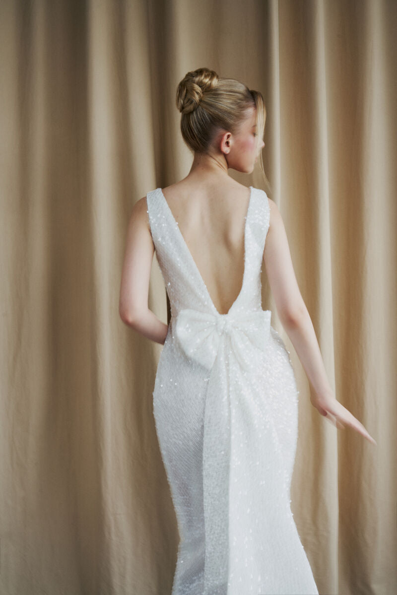Ivory sequined gown with scoop neck and bow details by HACCHIC COUTURE, elegant evening dress with sparkling embellishments.