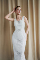 Ivory sequined gown with a scoop neck and bow details by HACCHIC COUTURE, shown in a stylish lookbook image.