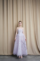 Strapless lilac tulle ball gown by HACCHIC COUTURE with a full, flowing skirt and elegant bodice, perfect for formal occasions.