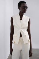 White LORA tailored vest by SÉLONE displayed on a mannequin, showcasing its sleek fit and classic design.