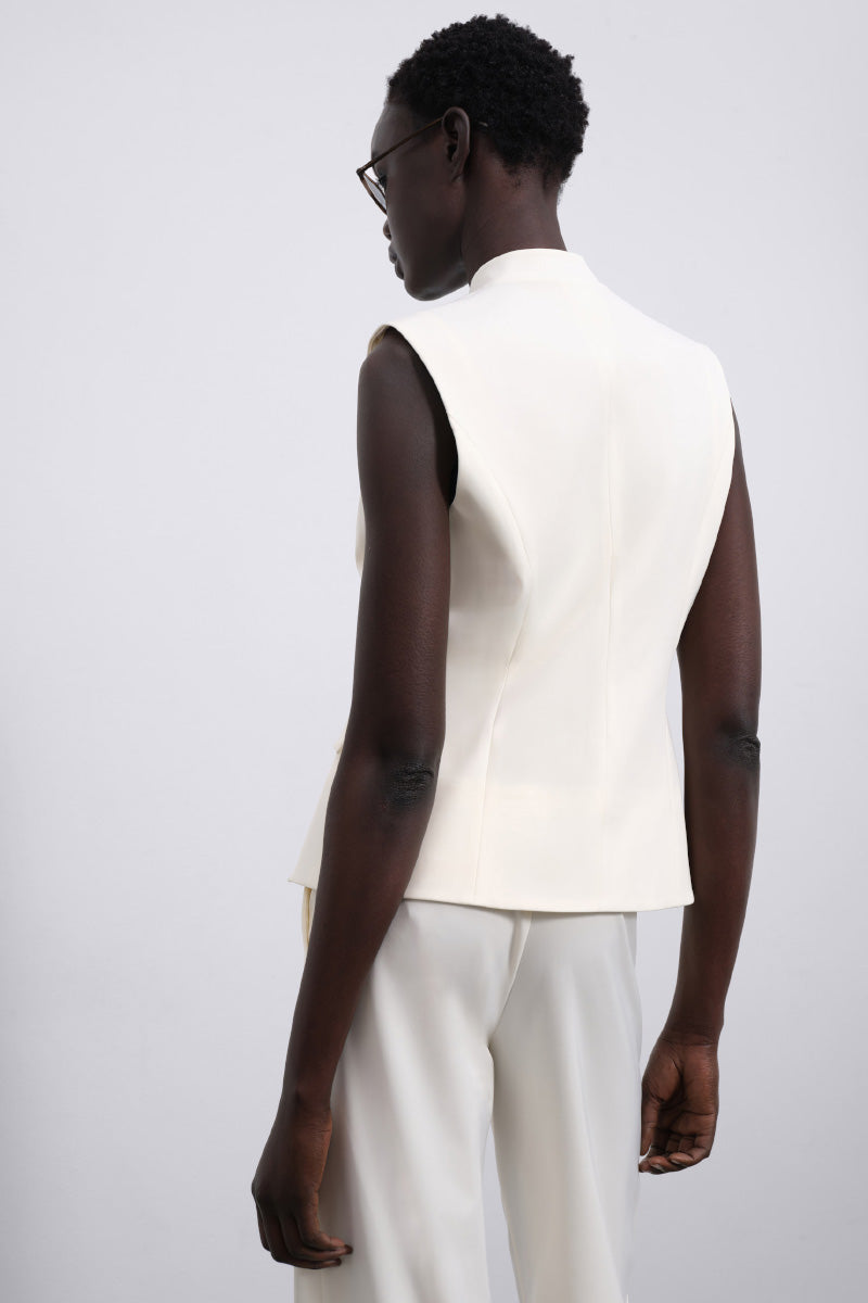 White LORA tailored vest by SÉLONE displayed on a mannequin, showcasing its sleek fit and classic design.