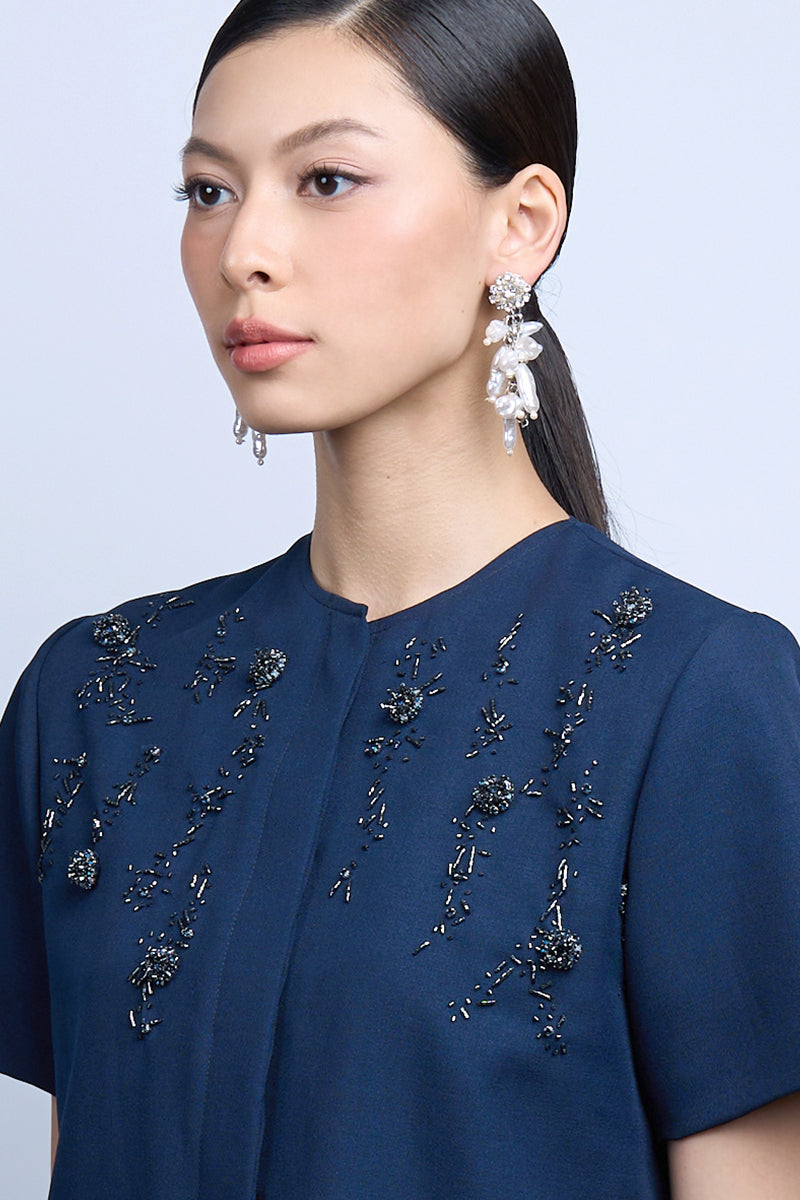 Aidan & Ice NEILLA white earrings featuring sleek, minimalist hoop design hanging from pierced ears.