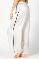 Side profile of NK IMODE Marisa Charming Silk Lounge Trouser in ivory, showcasing its relaxed fit and smooth silk fabric.
