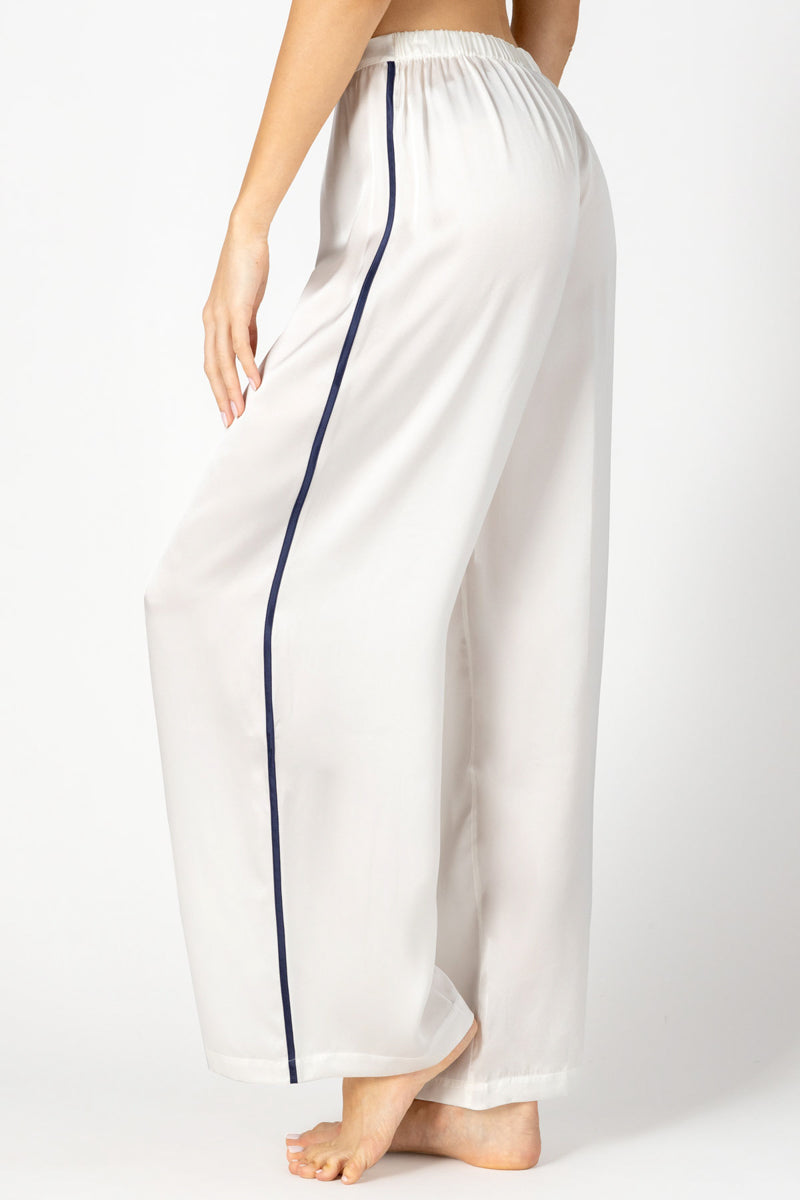 Side profile of NK IMODE Marisa Charming Silk Lounge Trouser in ivory, showcasing its relaxed fit and smooth silk fabric.