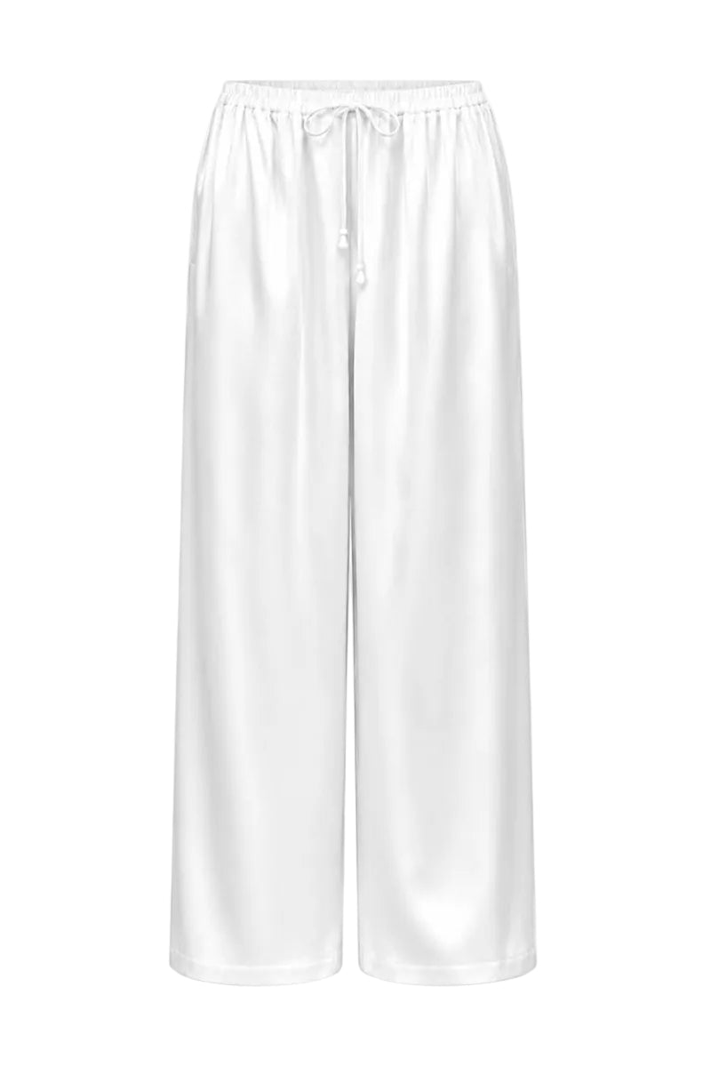 White Melanie pants by Izakova, featuring a relaxed fit and stylish design, displayed on a hanger.