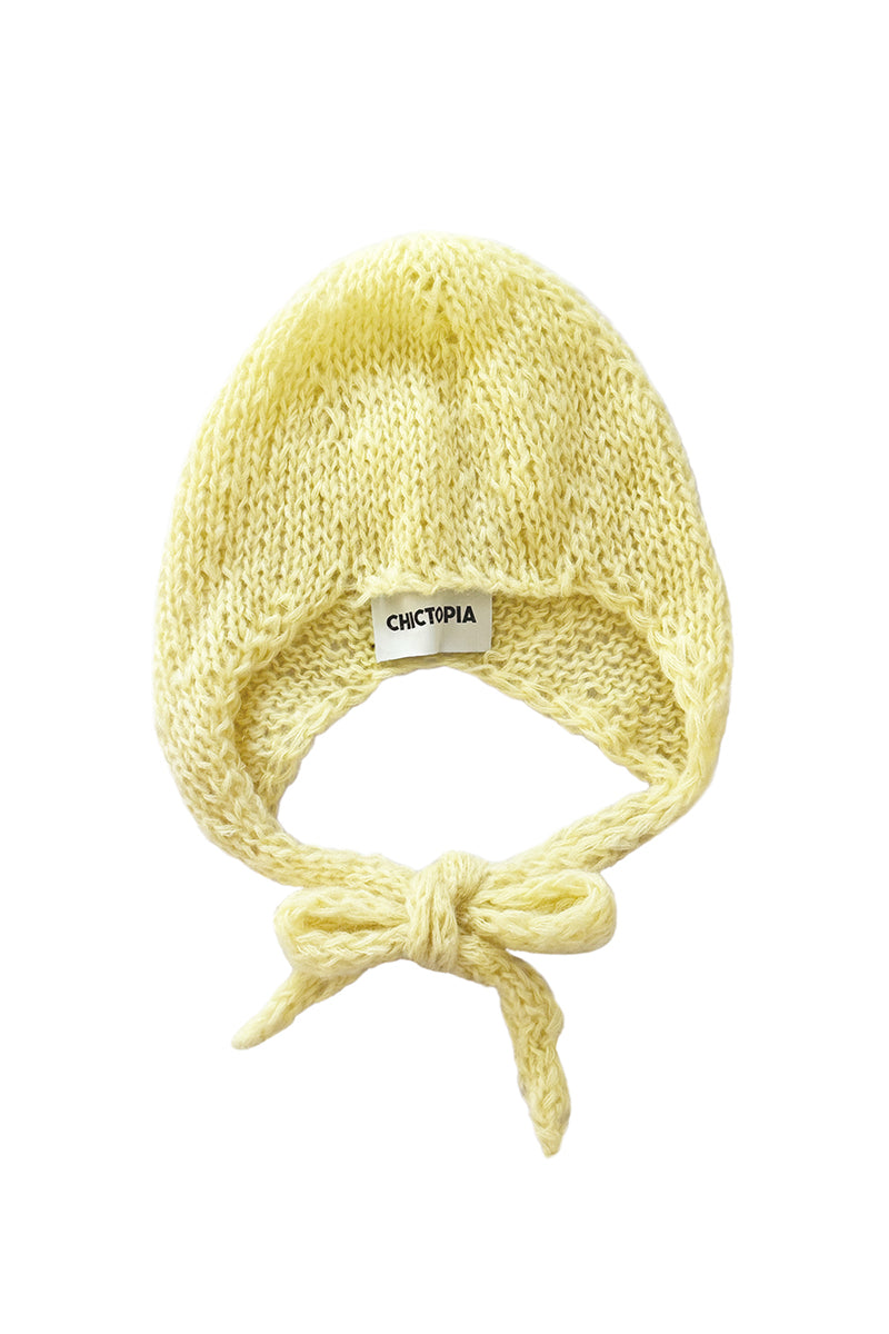 Hand-knitted yellow bonnet by Chictopia, showcasing a cozy, stylish hat with textured knit details and a snug fit.