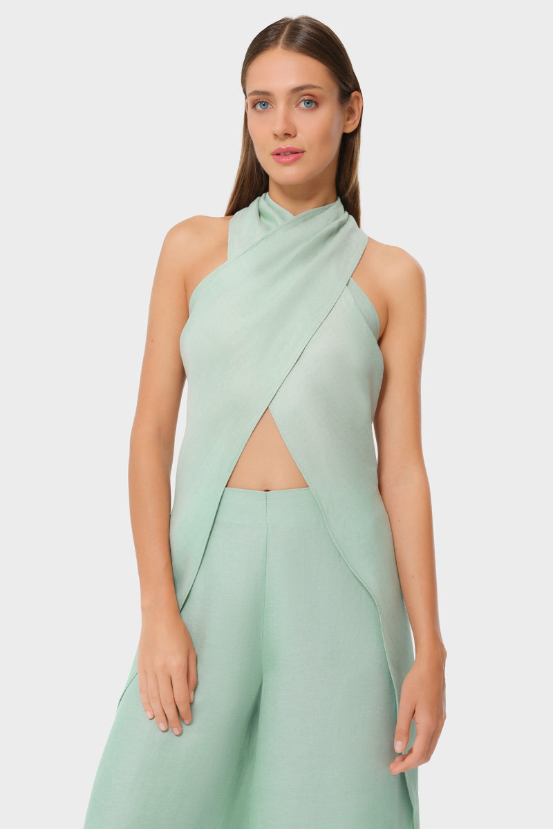 NiLuu Jade Liz cross halter top displayed on a hanger, featuring a stylish cut and vibrant jade color for a trendy look.