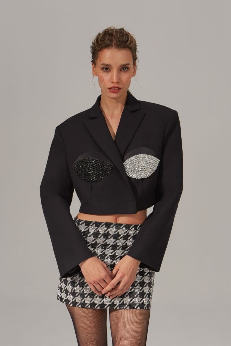 Nué cropped spiral black and silver blazer with a fitted design, featuring a sleek black and metallic silver pattern.