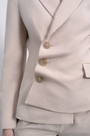 SÉLONE ORIS asymmetrical tailored blazer in warm beige, featuring a modern twist and structured fit.