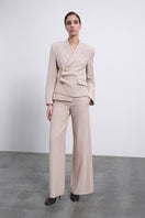 SÉLONE Oris asymmetrical tailored blazer in warm beige, featuring a modern twist and structured fit, on a neutral background.