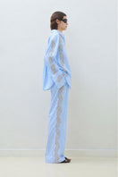 Blue embroidered pants with elastic waistband by TAGG, showcasing detailed embroidery and comfortable fit.