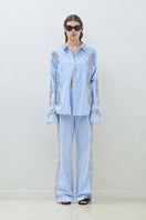 Blue embroidered pants with elastic waistband from TAGG, showing detailed stitching and relaxed fit.