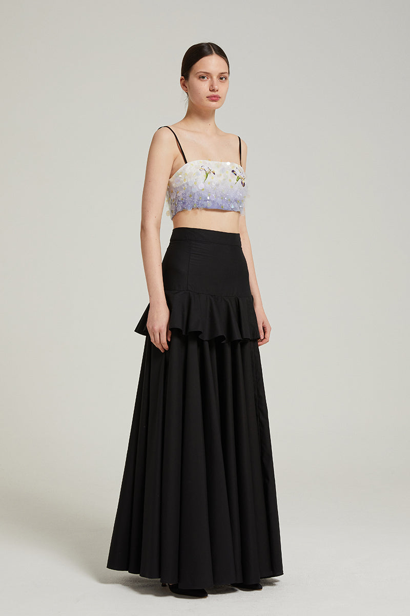 Black peplum maxi skirt by Nara Niro featuring a fitted waist, flowing length, and stylish peplum detail.