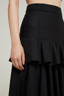 Black Nara Niro peplum maxi skirt featuring a fitted waist and flowing fabric, perfect for elegant, casual, or formal wear.