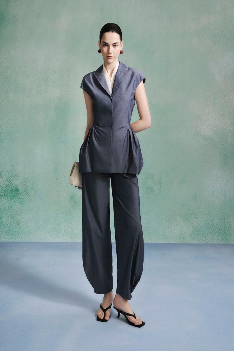 Lecia peplum top with fitted waist and flared hem, shown in a stylish, casual fit on a model.