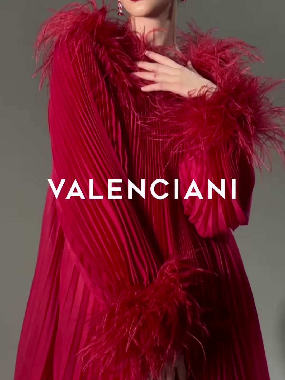ROBE PLISSÉE ROUGE BORDÉE DE PLUMES D'AUTRUCHE