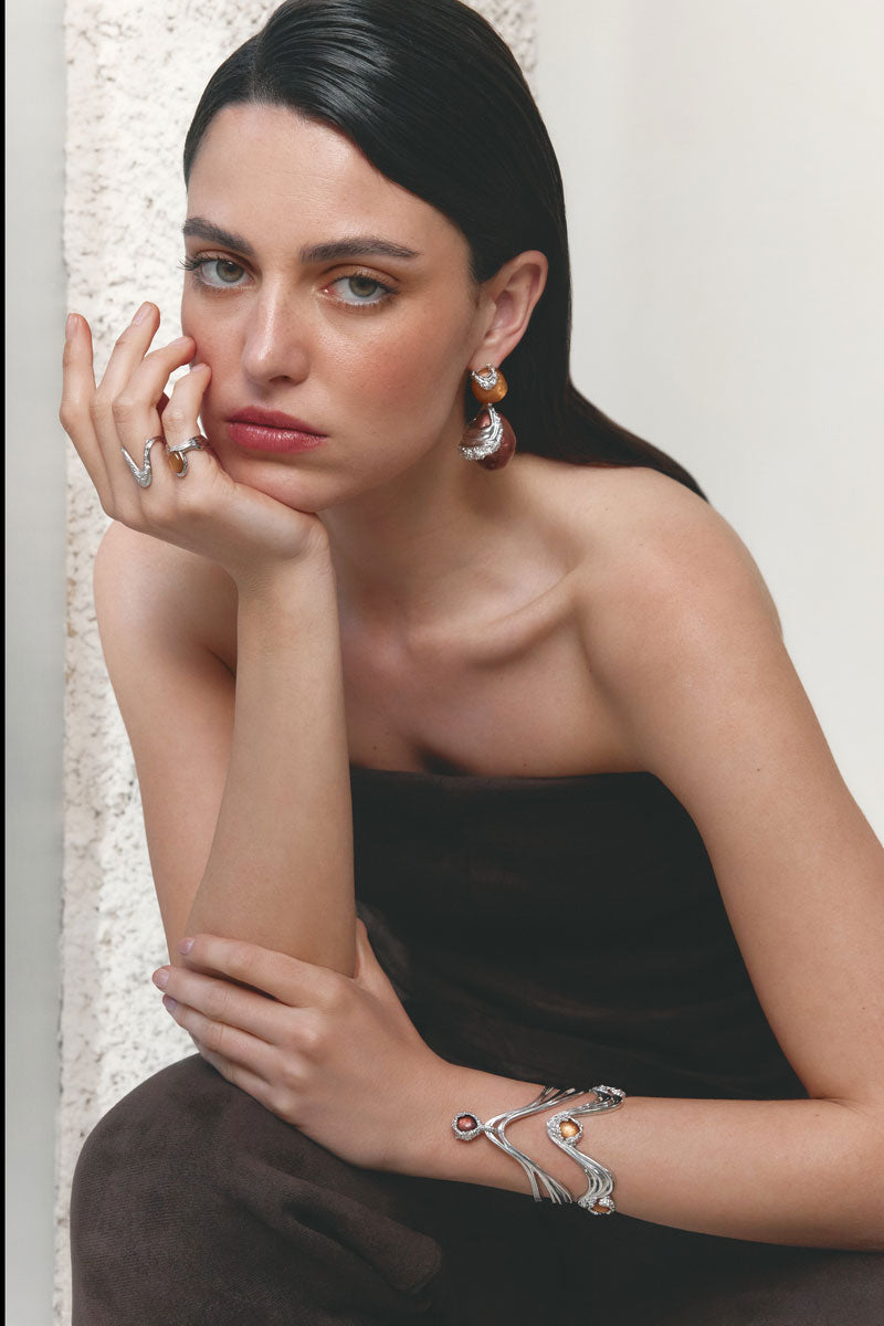 Silver drape ring by Jude Benhalim featuring a flowing, elegant design, shown on a model's finger.