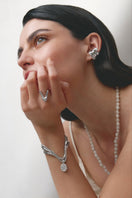 White Cascade Necklace by Jude Benhalim, featuring layered chain design displayed on a stand.