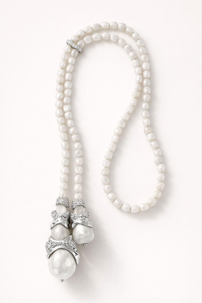 White Cascade necklace by Jude Benhalim featuring layered chain designs on a neutral background.