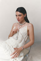 Silver and white drape bracelet by Jude Benhalim featuring elegant, flowing design with intricate details.