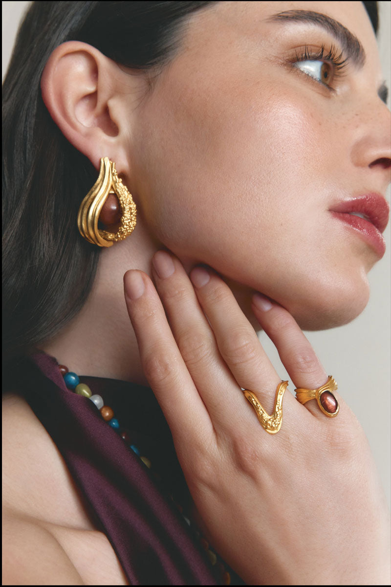Gold and white anchor ring by Jude Benhalim, showcasing a sleek and stylish jewelry design in a close-up view.