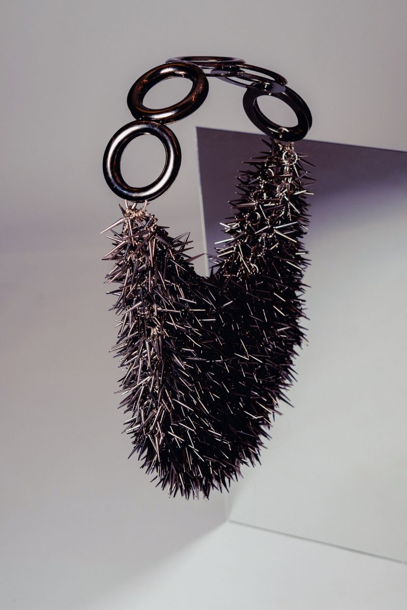 Gray punk metallic top handle bag by Millanne Tale with a bold, edgy design and structured shape.