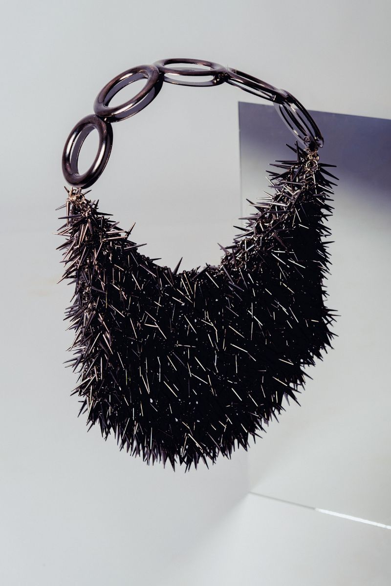 Gray PUNKA silver metallic top handle bag by Millanne Tale with a bold, edgy punk-inspired design and sturdy handle.