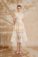 Rosee de Matin Yasmine A-line short-sleeved lace midi dress displayed on a hanger, showcasing its elegant design and intricate lace details.