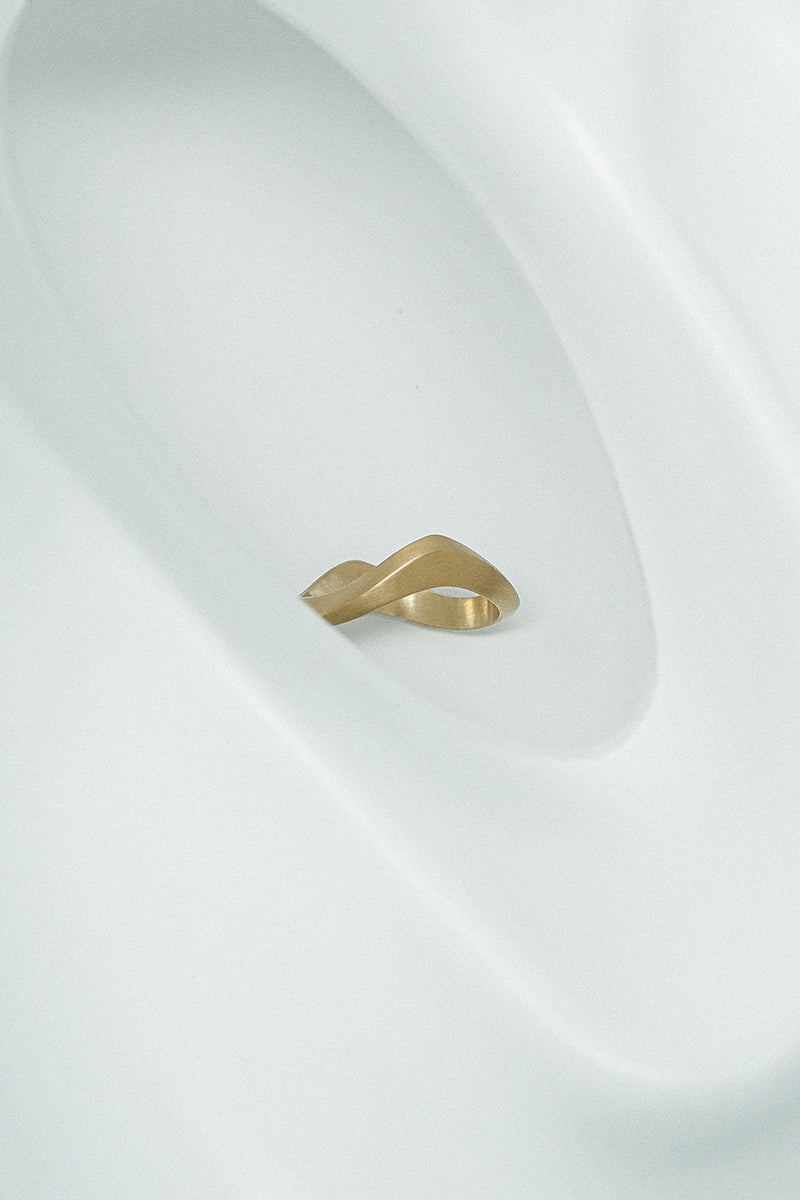 Matte gold sand ring by EDXÚ featuring a textured, natural-inspired design, styled on a model's finger.