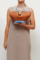 Mini Capazo caramel and blue sky top handle bag by Saonara, showing its woven design and stylish handle details.