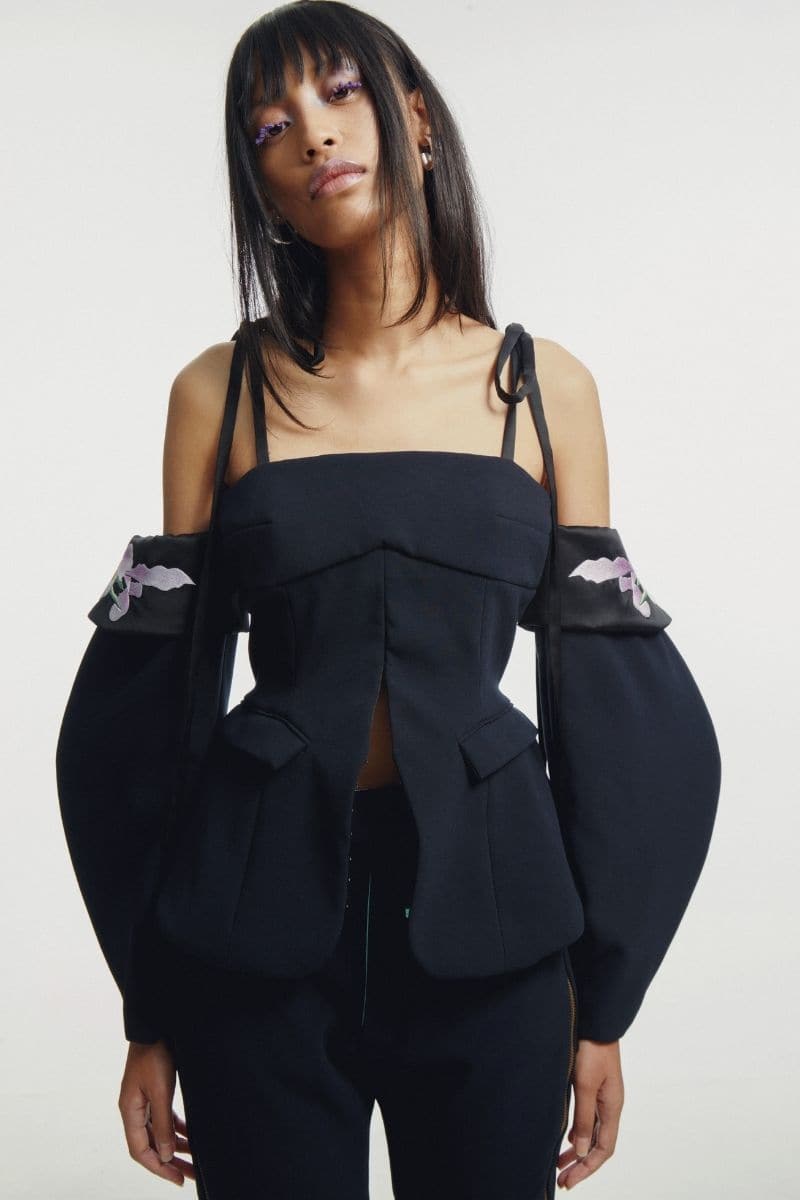 Black embroidered tailored top by Sean Sheila, featuring intricate embroidery and a fitted design, shown in black size XXS.
