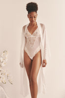 Sheer white mesh bodysuit by Luciela, featuring long sleeves and a fitted design, shown on a plain background.