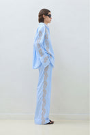 Blue embroidered oversize shirt by TAGG, casual fit with detailed embroidery, shown on a hanger.