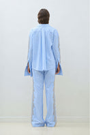 Blue embroidered oversized shirt by TAGG, featuring detailed embroidery and relaxed fit, shown on a hanger.