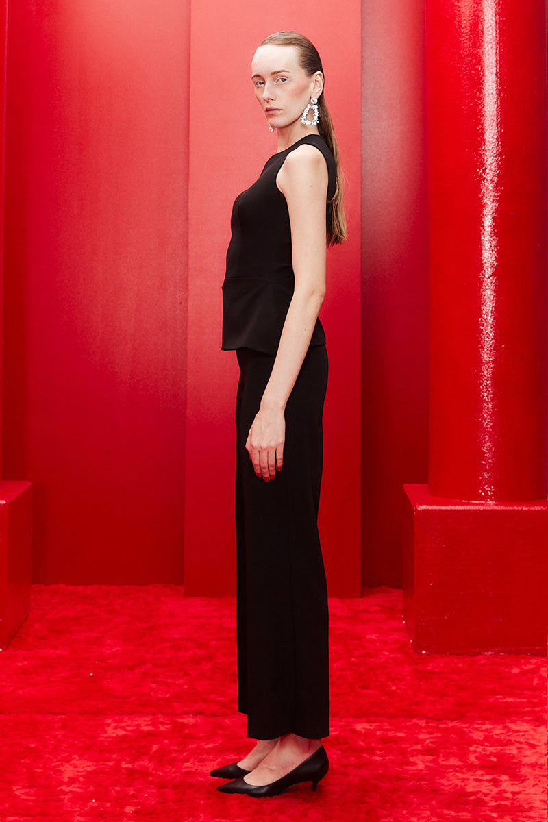 Joanna Andraos midnight black co-ords set with top, pants, and detachable emerald cape, shown from side view.