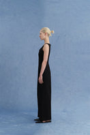 Black asymmetric-beck sleeveless jumpsuit by JINSUN, shown from a side angle, featuring a stylish, modern design.