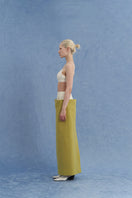 Green JINSUN maxi pencil skirt with a fitted side view, showcasing its sleek and elegant design.