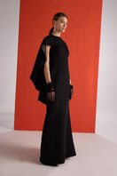 Joanna Andraos black cascade gown shown from the side, featuring flowing fabric and elegant design for formal occasions.