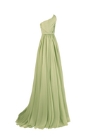Light green strapless gown by Joanna Andraos, elegant side view showing flowing fabric and sophisticated design.