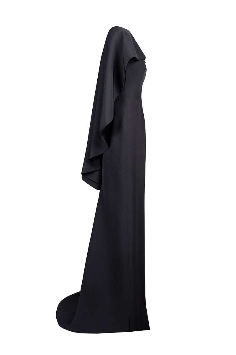Side view of Joanna Andraos black cascade gown featuring flowing fabric and elegant design for formal occasions.