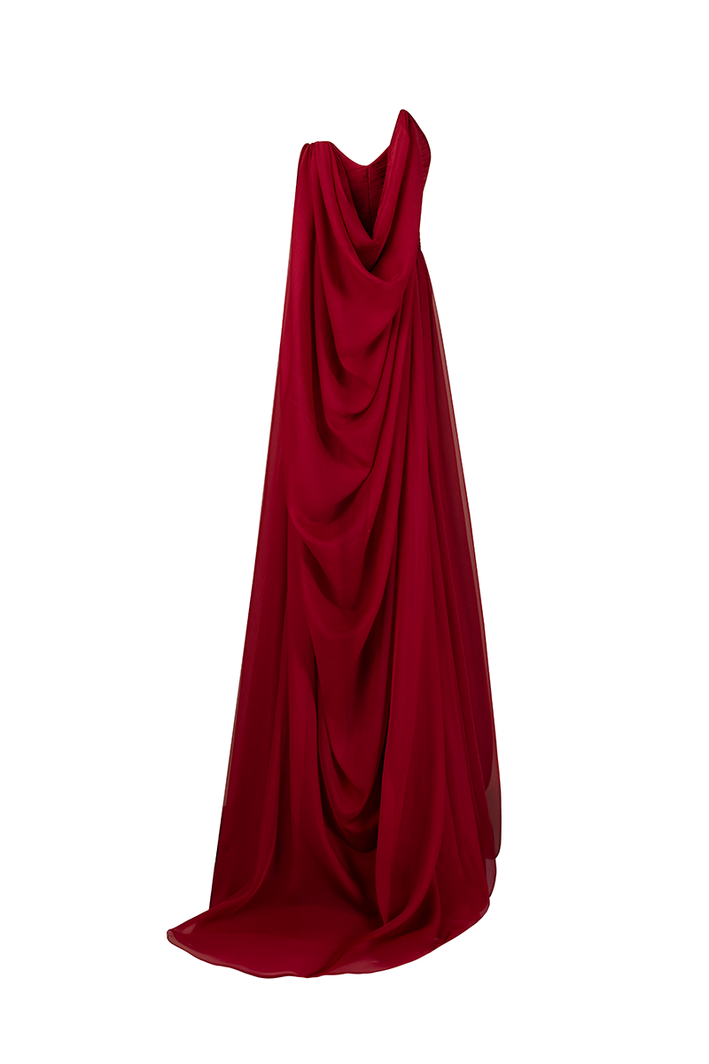 Side view of a red strapless gown by Joanna Andraos, featuring elegant draping and a fitted silhouette.