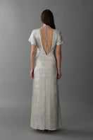 A stylish ivory ruched center column gown by Aisl, featuring elegant draping and a fitted silhouette, shown from the back.