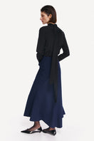 Midnight blue midi skirt by DELEGAN displayed from the back, featuring a sleek, flowing design perfect for stylish outfits.