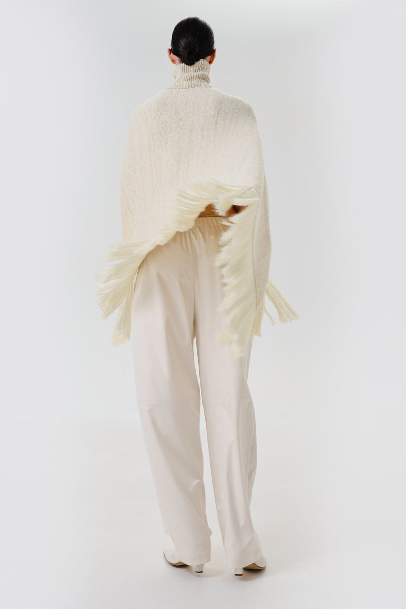 DELEGAN milk blush poncho cardigan styled back view, soft knit fabric with a relaxed fit and cozy design.