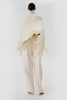 DELEGAN milk blush cardigan poncho displayed from the back, featuring a cozy, stylish knit design in soft milk blush color.