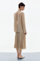 DELEGAN nude gold long sleeve blouse styled back, showing the elegant shirt with a relaxed fit and smooth fabric.