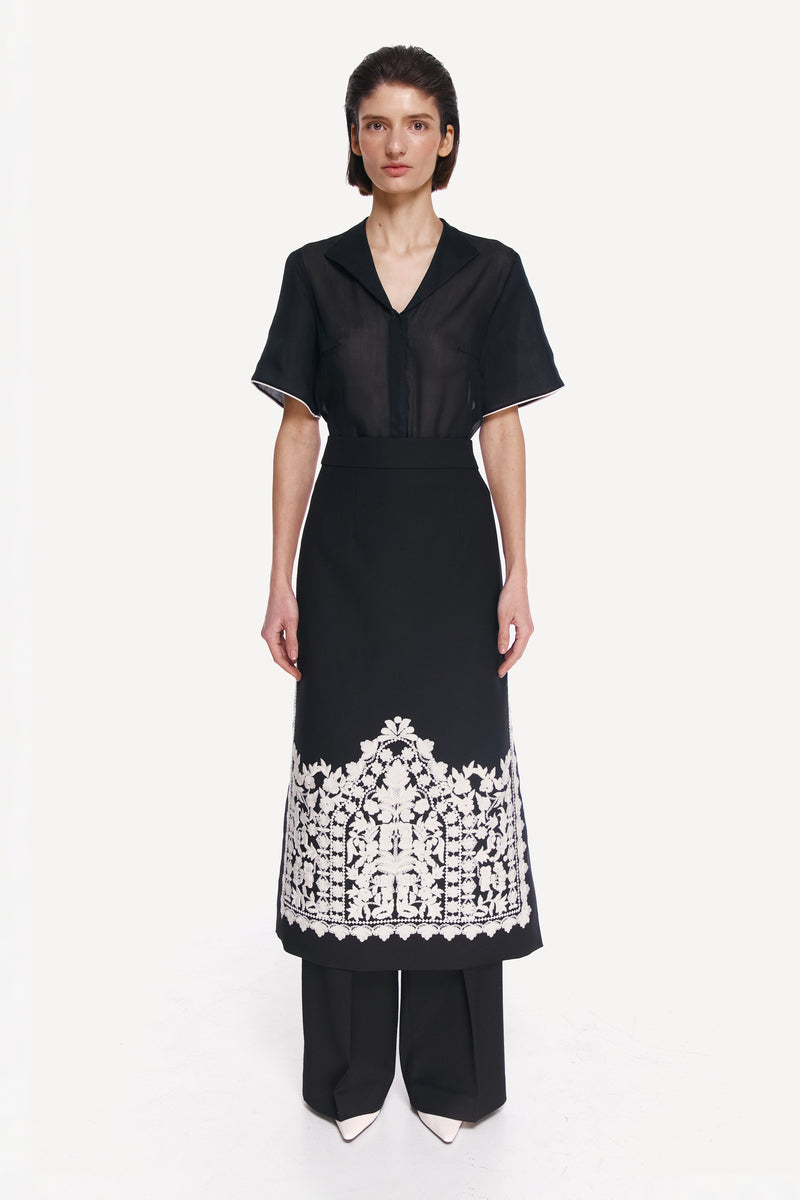 Black DELEGAN shirt with white edging, front view showcasing the stylish collar and clean design.