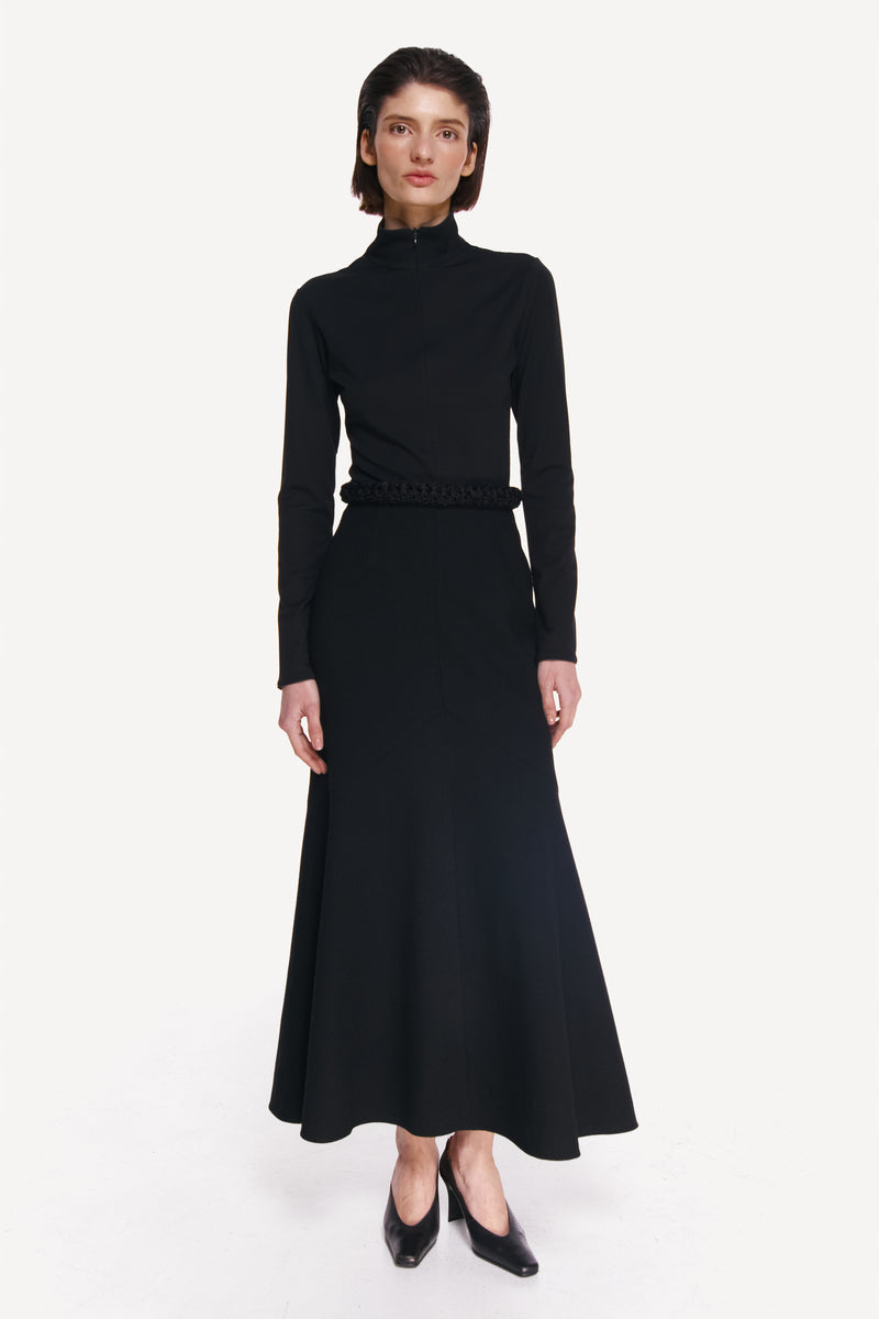 Black coal long sleeve top by DELEGAN, styled front view showing fitted design and round neckline.